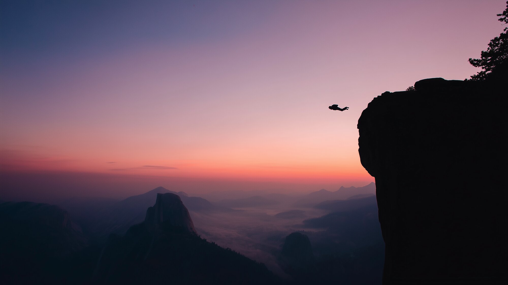 A base jumper just after jumping off a cliff